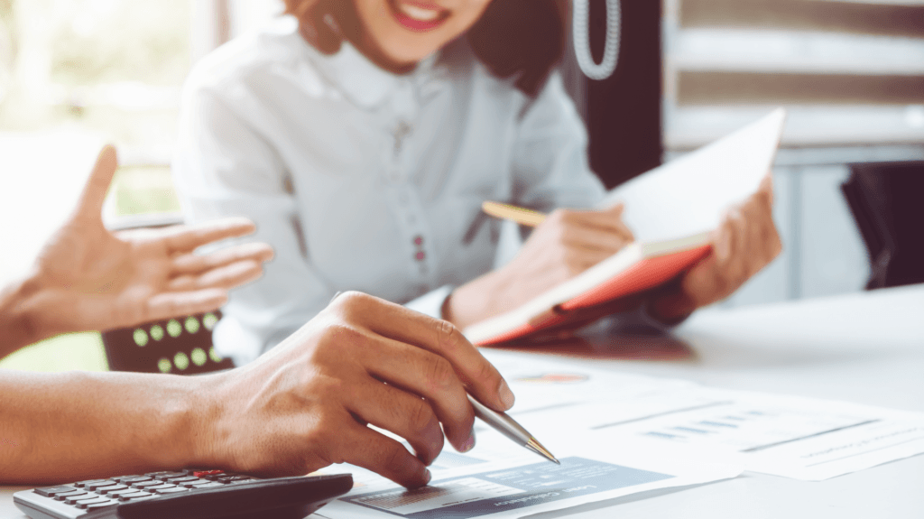 Pessoas em discussão à mesa de escritório, simbolizando comparação entre canal de denúncias e ouvidoria